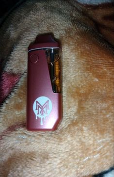 an electronic device is laying on top of a dog's fur with the logo m & m written on it