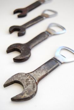 four wrenches are lined up on a white surface