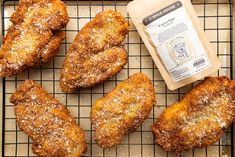 some fried food on a cooling rack with a bag of seasoning next to it