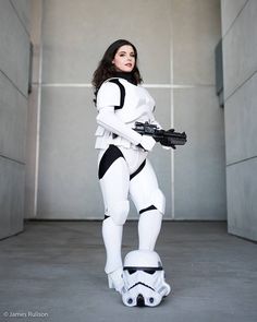 a woman dressed as storm trooper standing on top of a skateboard