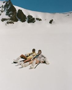 three people are laying in the snow together