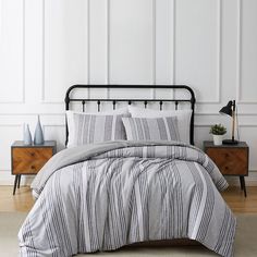 a black and white striped comforter on a bed in a room with two nightstands