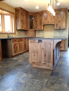 a kitchen with wooden cabinets and an island in the middle of the room, surrounded by tile flooring