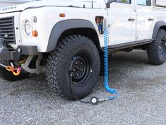 the front end of a white truck with a blue hose attached to it's tires