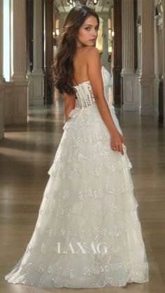 a woman in a white wedding dress standing on the floor with her back to the camera