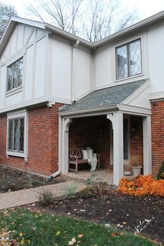 an outside view of a house with flowers in the front yard