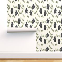 black bears and trees on white wallpaper in a room with wood flooring next to the wall