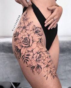 a woman's thigh with flowers on it and the bottom half of her leg