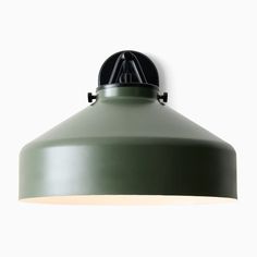 a green light hanging from the side of a ceiling fixture with a white wall in the background