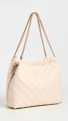 Find TORY BURCH Fleming Soft Drawstring Hobo Bag on Editorialist. The Tory Burch Fleming Soft Drawstring Hobo Bag is crafted from lambskin leather and features a raised check pattern. The bag has gold-tone hardware, a magnetic snap closure, and a chain shoulder strap. The interior features a patch pocket and a zip pocket. The bag is lined with microfiber and measures 12.5 inches in height, 15 inches in length, and 4.25 inches in depth. The strap drop is 10.25 inches. This hobo bag can fit a 12-i Luxury Beige Bucket Bag With Intrecciato Weave, Elegant Beige Bucket Bag With Intrecciato Weave, Luxury Beige Hobo Bag With Dust Bag, Beige Bucket Bag With Chain Strap, Beige Bucket Shoulder Bag With Chain Strap, Beige Pouch Shoulder Bag With Intrecciato Weave, Beige Shoulder Bucket Bag With Chain Strap, Luxury Beige Pouch Hobo Bag, Beige Intrecciato Weave Pouch Shoulder Bag