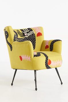 a yellow chair with an animal print on the back and arms, sitting in front of a white background