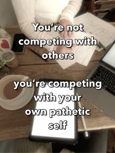 a woman sitting at a table with a laptop and papers in front of her that says, you're not competing with others you're competing with your own psychic self