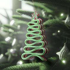 a green christmas tree ornament hanging from a fir tree