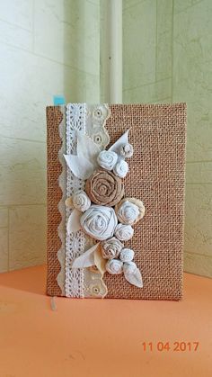 an image of a card with flowers and laces on it's side, sitting on a table