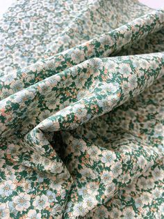 the fabric is green and white with flowers on it