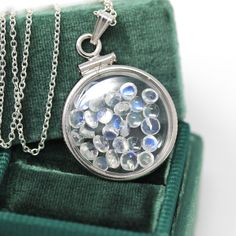 "Magical handcrafted brand new sterling silver genuine moonstone shaker locket! This whimsical pendant is dime sized with coin style bezels, and clear lucite covers. The round charm hangs from a brand new sterling silver chain, and is filled with approximately 2.5 carats of cabochon and round cut moonstone gems. An otherworldly piece of brand new gemstone jewelry, that features the optical phenomenon; adularescence! ERA - New METAL / MATERIAL - Sterling silver locket, sterling silver chain, luci Moonstone Round Pendant Jewelry For Gift, White Gold Moonstone Round Pendant Jewelry, Silver Moonstone Round Pendant Jewelry, Unique Moonstone Round Pendant Jewelry, Silver Medallion Birthstone Jewelry, Spiritual Sterling Silver Coin Jewelry, Spiritual Sterling Silver Round Pendant Gemstone, Silver Medallion Jewelry With Birthstone, Spiritual Moonstone Jewelry For Collectors