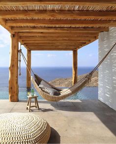 a hammock hanging from the side of a building next to an ocean view