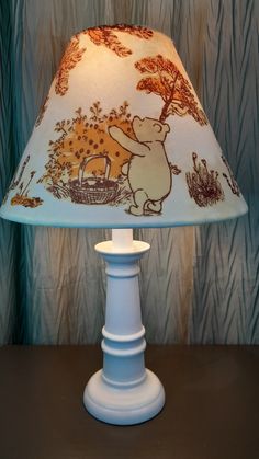 a lamp that is on top of a table with a bear and giraffe print shade