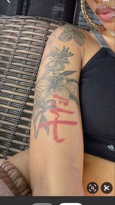 a woman with a tattoo on her arm sitting in front of a wicker chair