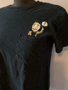 a black t - shirt with an image of a man holding a phone in his pocket