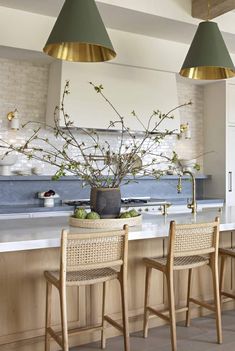 an image of a kitchen setting with bar stools and flowers on the counter top