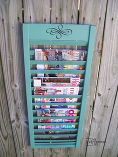 a magazine rack is mounted on the side of a wooden fence