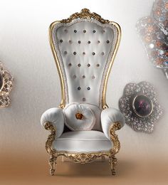 an ornate white chair with gold trimmings in front of a wall mounted mirror