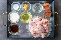 an overhead view of raw chicken, sauces and condiments on a tray