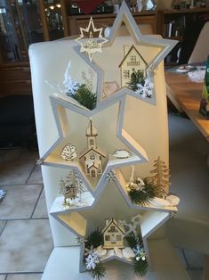 a christmas tree made out of cardboard with houses and snowflakes on the top