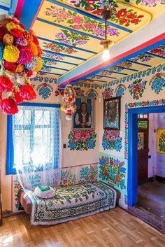 an ornate room with floral decorations on the ceiling and wooden floors, painted in bright colors