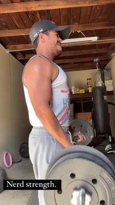 a man holding a barbell in his garage