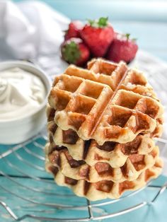 a stack of waffles sitting on top of a cooling rack next to strawberries