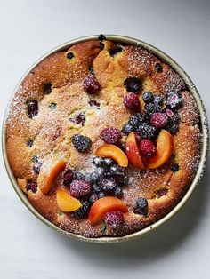 a bowl filled with fruit and powdered sugar on top of a white countertop