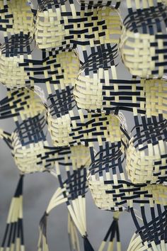 several woven objects are arranged in the shape of birds on sticks with black and yellow strips