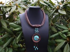 Add a touch of bohemian flair to your outfit with this exquisite Vintage Bohemian handmade necklace featuring a long pendant made of coconut shell and turquoise howlite beads. The intricate design is reminiscent of cherry blossoms in full bloom, making it a unique and eye-catching statement piece. Elevate your style with this one-of-a-kind accessory that will surely spark conversations wherever you go. Rustic Turquoise Jewelry For The Beach, Hippie Pendant Necklaces For Beach, Bohemian Adjustable Turquoise Necklace With Wooden Beads, Hippie Beach Pendant Necklaces, Adjustable Bohemian Turquoise Necklace With Wooden Beads, Hippie Beach Pendant Necklace, Bohemian Turquoise Necklace With Wooden Beads, Bohemian Brown Turquoise Necklace For Jewelry Making, Handmade Bohemian Turquoise Necklace For Beach