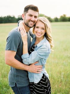 a man and woman hugging each other in a field