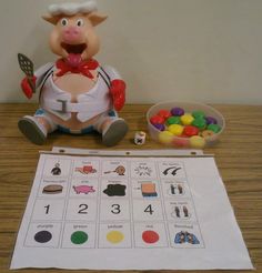 a toy pig sitting on top of a wooden table next to a calendar and candy