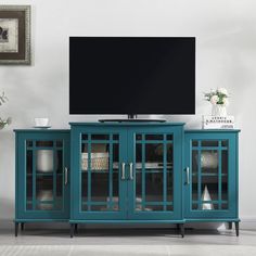 a flat screen tv sitting on top of a blue cabinet