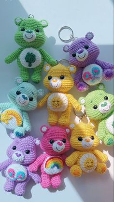 several crocheted teddy bears sitting next to each other on a white surface with a keychain