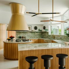 a kitchen with marble counter tops and wooden stools in front of an island that has three black bar stools on it