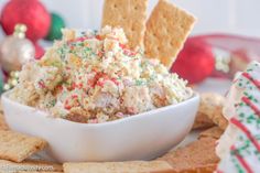 a bowl filled with cake mix surrounded by crackers and candy canes on a plate