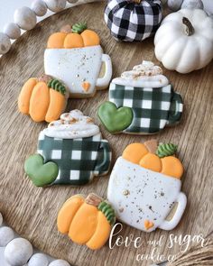 some decorated cookies are sitting on a tray next to pumpkins and other fall decorations