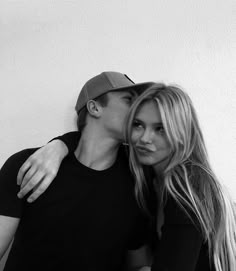 a man and woman are posing for a black and white photo with their arms around each other