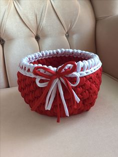 a red and white basket sitting on top of a chair