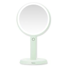 a round mirror sitting on top of a white table next to a light green stand