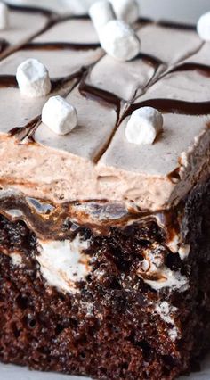 a piece of chocolate cake with marshmallows on top and frosting in the middle