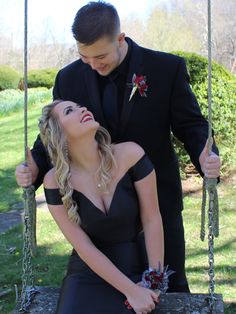 a man and woman are sitting on a swing