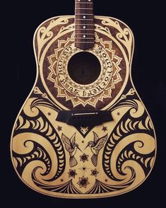 a wooden guitar with an intricate design on it