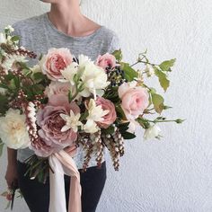 a woman holding a bouquet of flowers in her hands