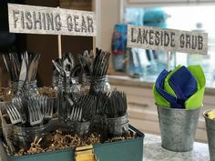 there are many forks and spoons in the container on the table with fishing gear